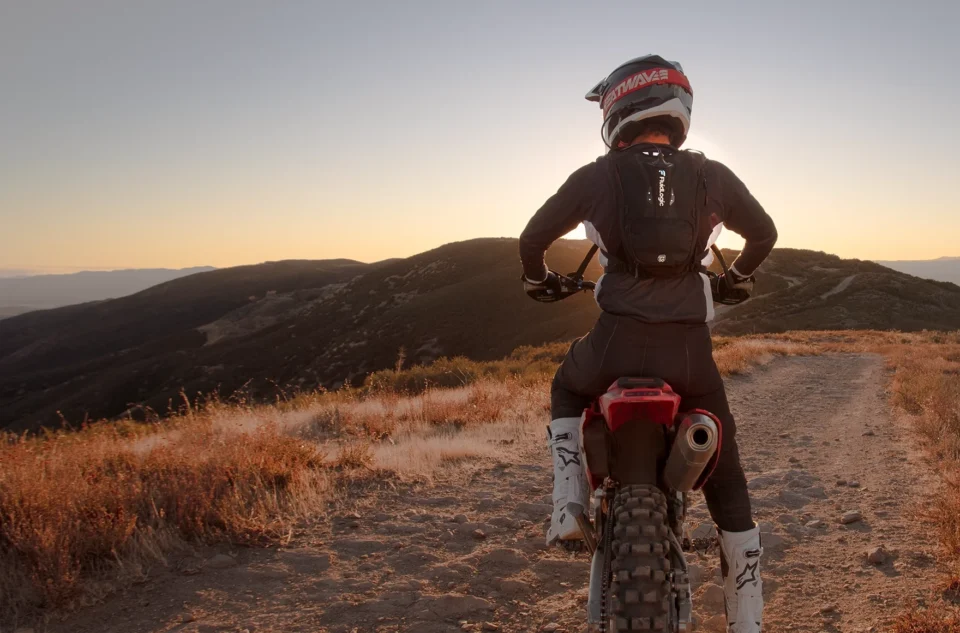 Person on top of mountain on a motorbike with a fluid logic pack